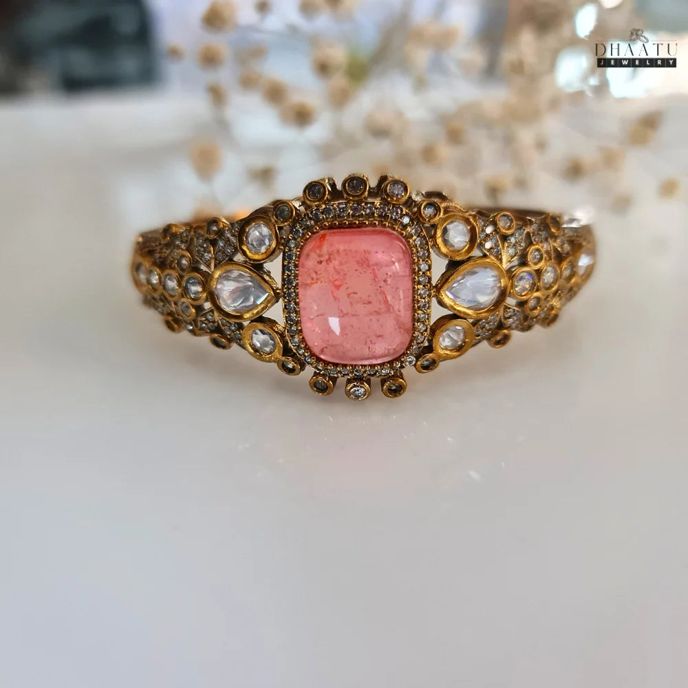 Dhaatu festive bracelet with pink stone and white accents displayed against a soft white background.
