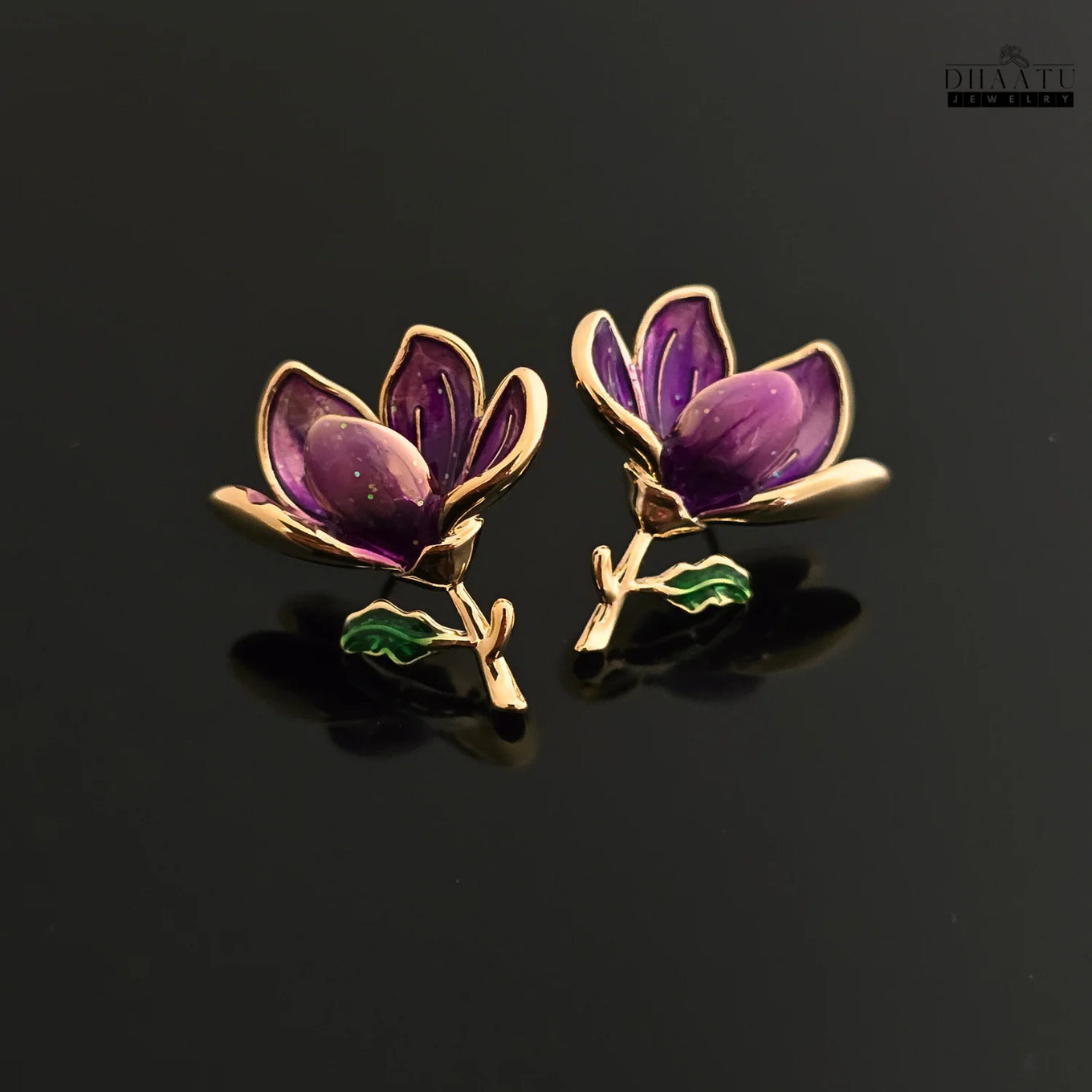 A pair of Dhaatu Jewelry purple enamel floral stud earrings shown against a black reflective background, highlighting their elegant design and glossy finish.