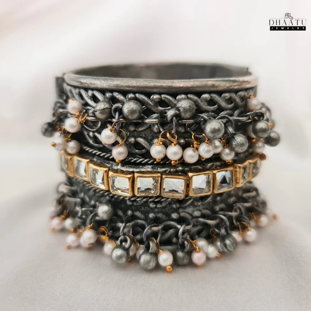Close-up of intricate Kundan stone work and pearl embellishments on oxidized silver cuff