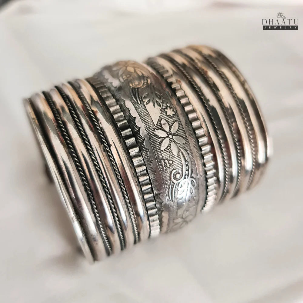 Close-up shot of the oxidized silver tribal cuff bracelet, focusing on the intricate floral and textured details against a white background.
