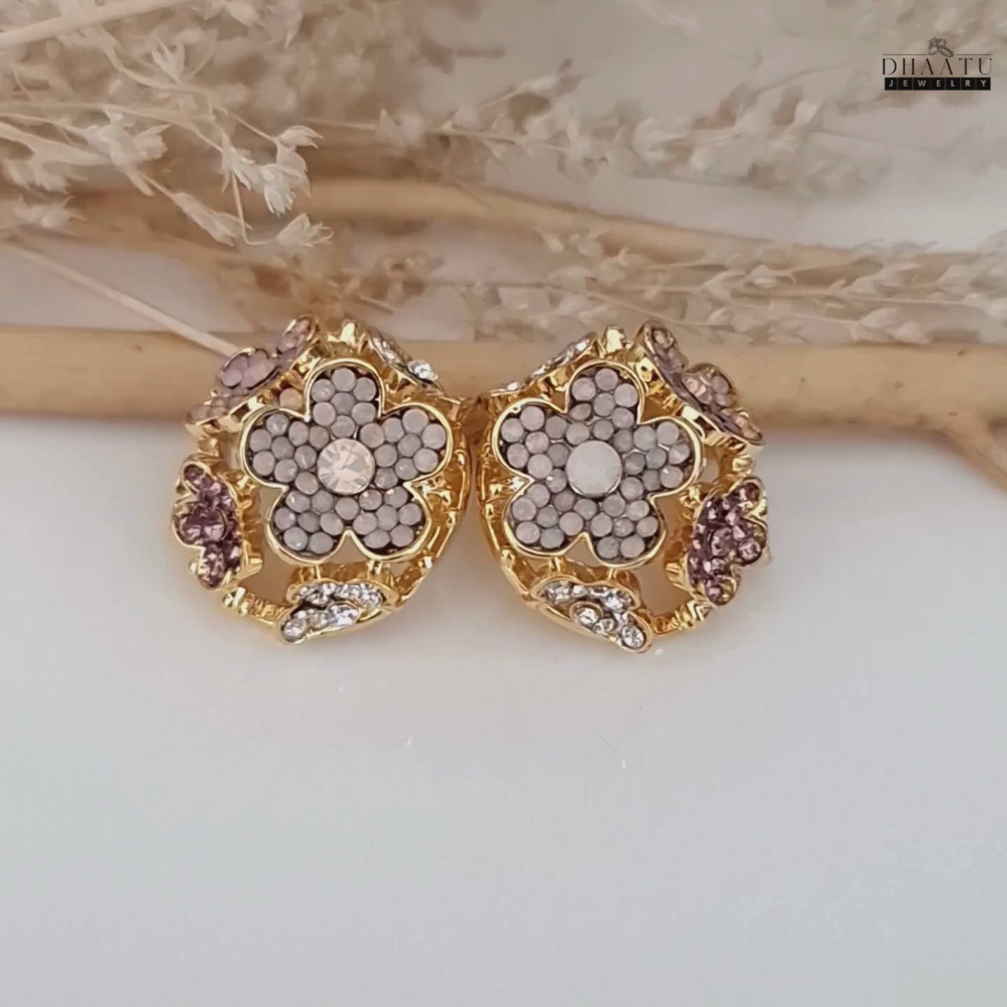 Load video: Video showcasing the intricate design and sparkle of the rose gold-plated floral stud earrings.