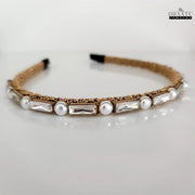 Chic artificial jewelry hairband with gold weave, pearls, and clear crystals on a white background, highlighting its contemporary design.