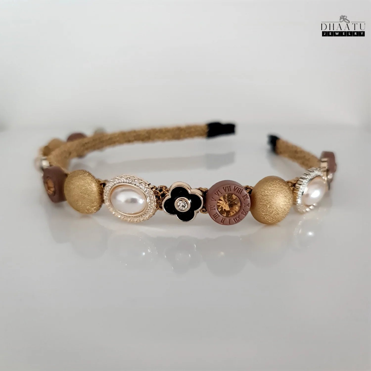 Chic beaded headband with gold, pearl, and crystal embellishments displayed against a bright, light background, highlighting its intricate details