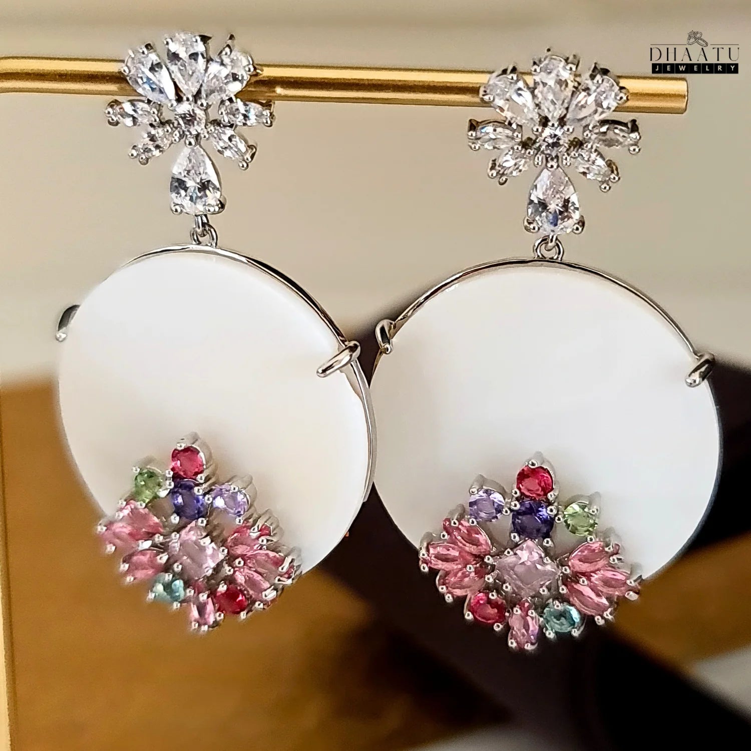 Dhaatu Jewelry floral stud dangle earrings with colorful stones and CZ studs hanging from a gold bar.