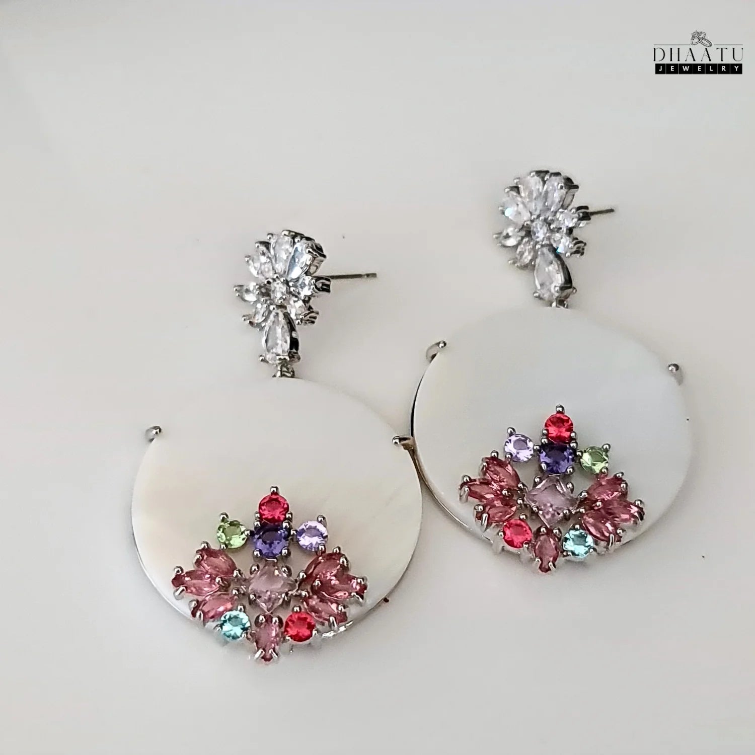 Pair of Dhaatu Jewelry floral stud dangle earrings with colorful stones on a white background.
