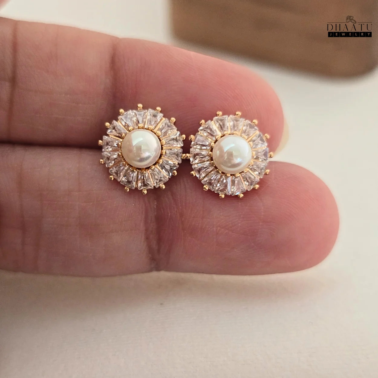 DHAATU JEWELRY Pearl and Cubic Zirconia Sunburst Stud Earrings held in a hand, displaying size and detailed craftsmanship