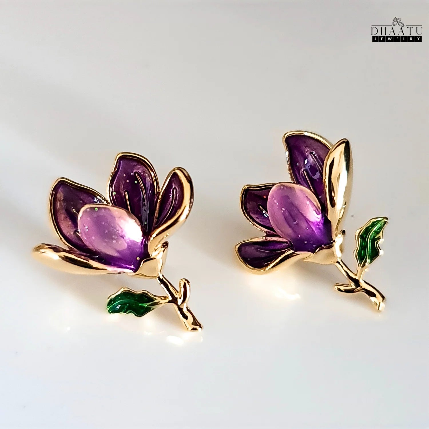 A pair of Dhaatu Jewelry purple enamel floral stud earrings displayed on a clean white background, offering a clear and detailed front view of the product.