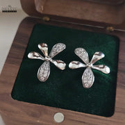 Dhaatu Jewelry silver-plated floral stud earrings resting in a green velvet-lined wooden box