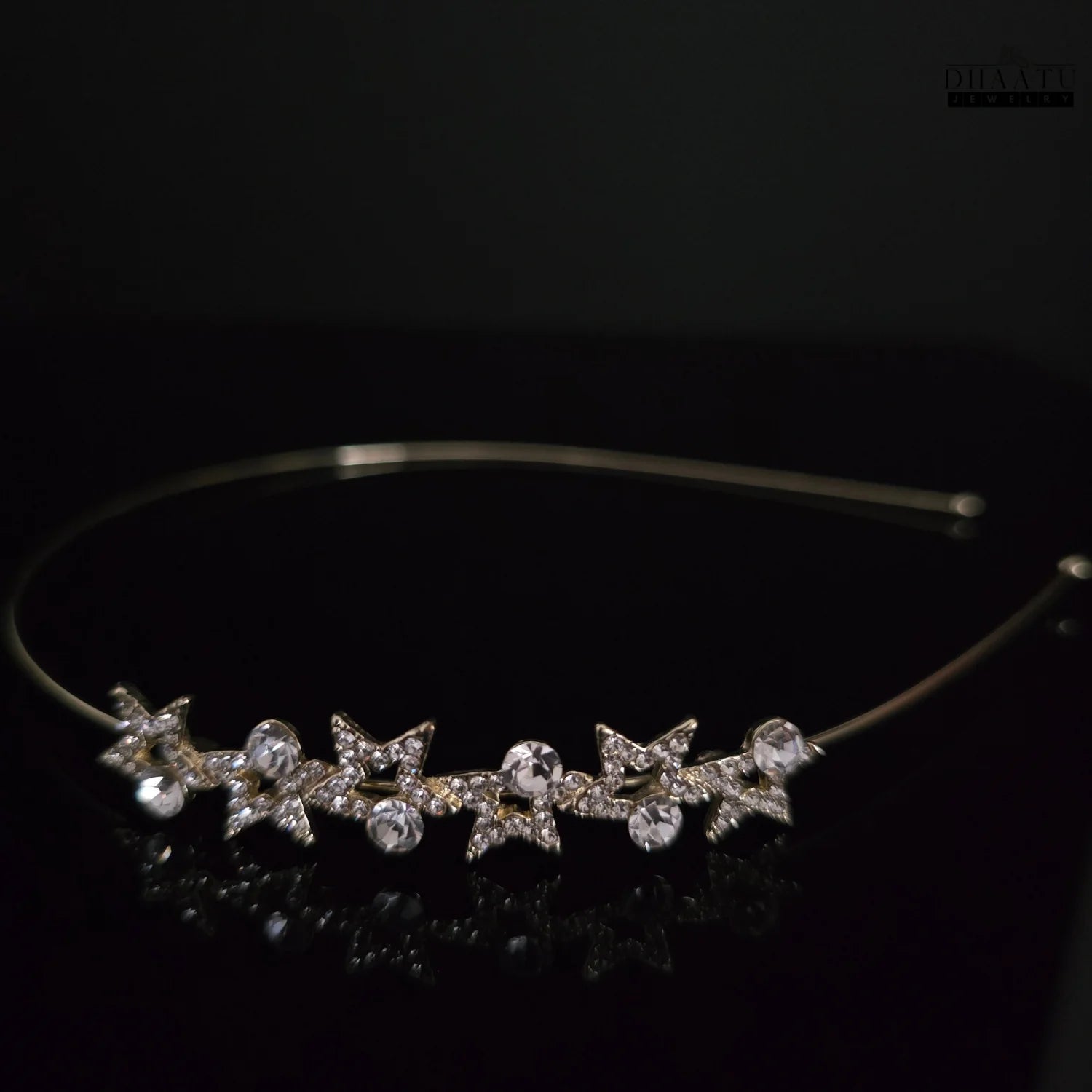 Front view of DHAATU JEWELRY Starlight Crystal Embellished Gold-Toned Hairband with five sparkling star designs and clear round crystals