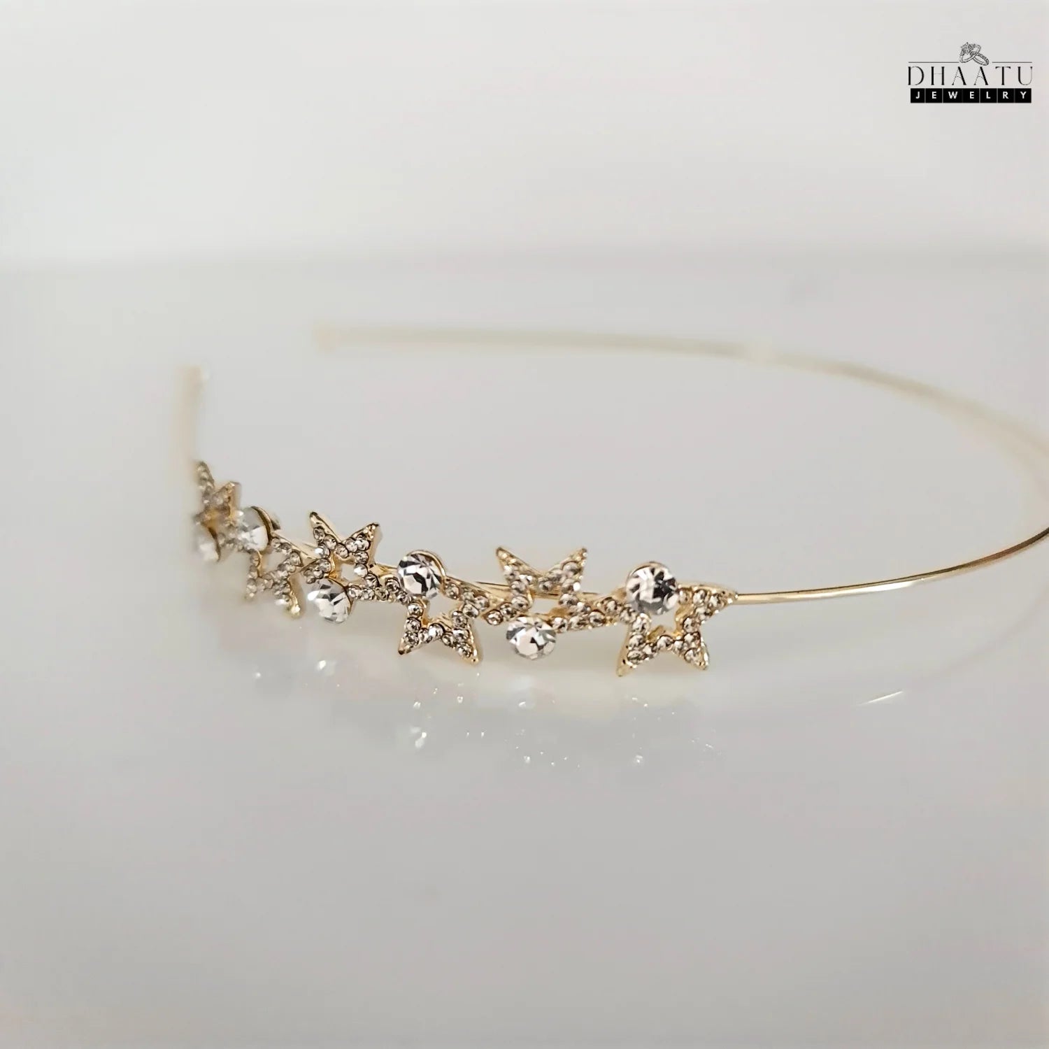 DHAATU JEWELRY Starlight Crystal Embellished Gold-Toned Hairband on a light background, highlighting the reflective quality of the crystals