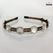 Elegant crystal embellished hairband featuring a brown braided band, displayed on a clean white background