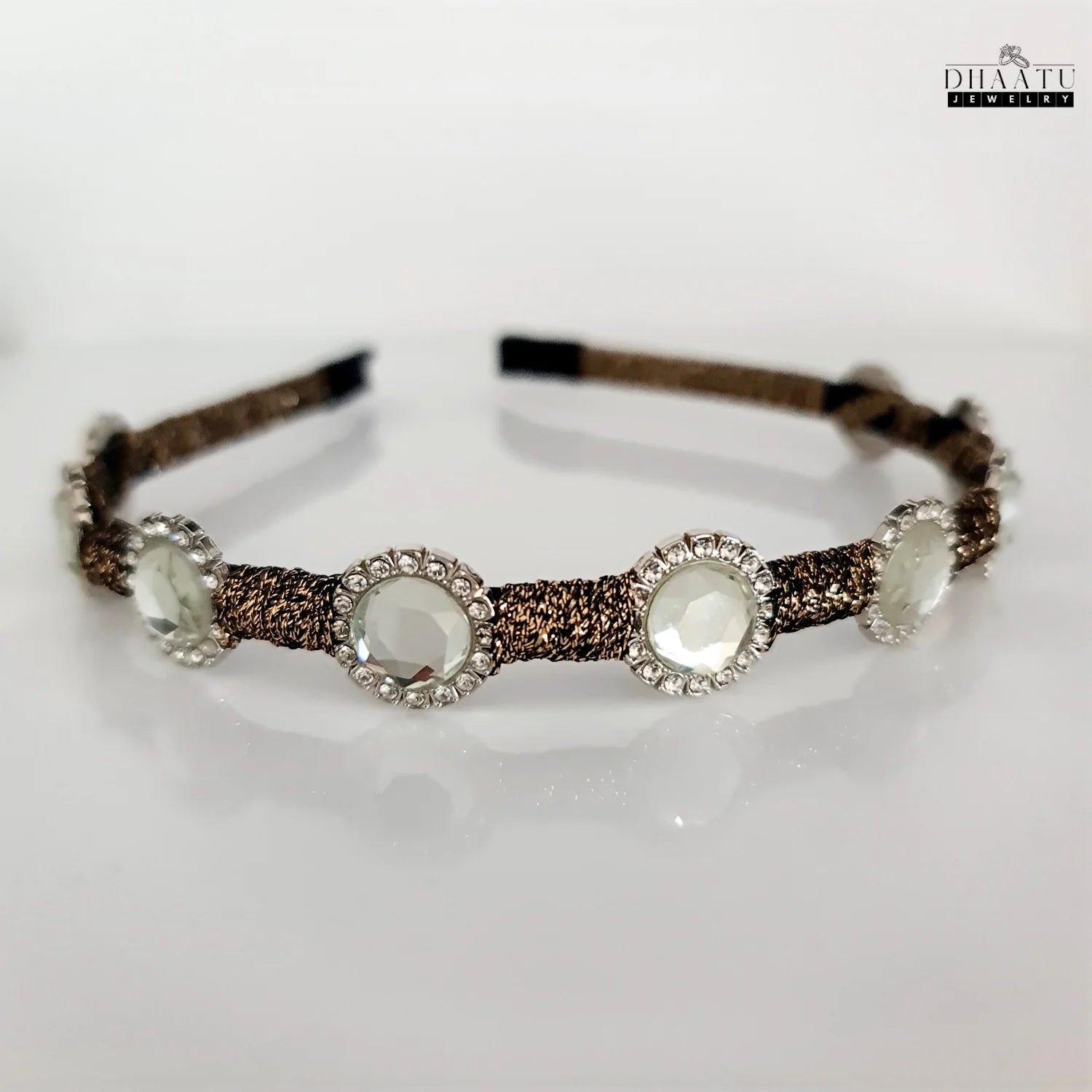 Elegant crystal embellished hairband featuring a brown braided band, displayed on a clean white background