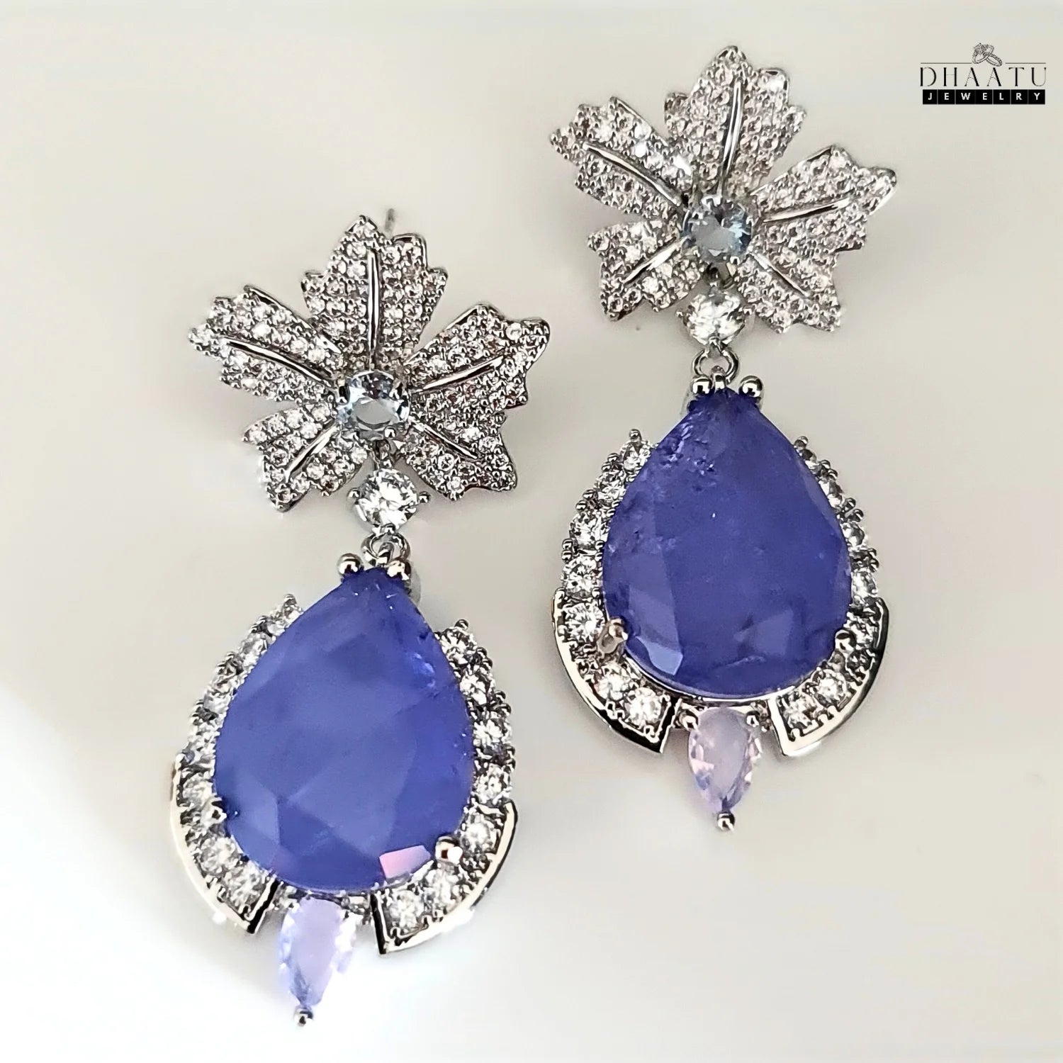 The silver-toned tanzanite drop earrings displayed on a clean white background.