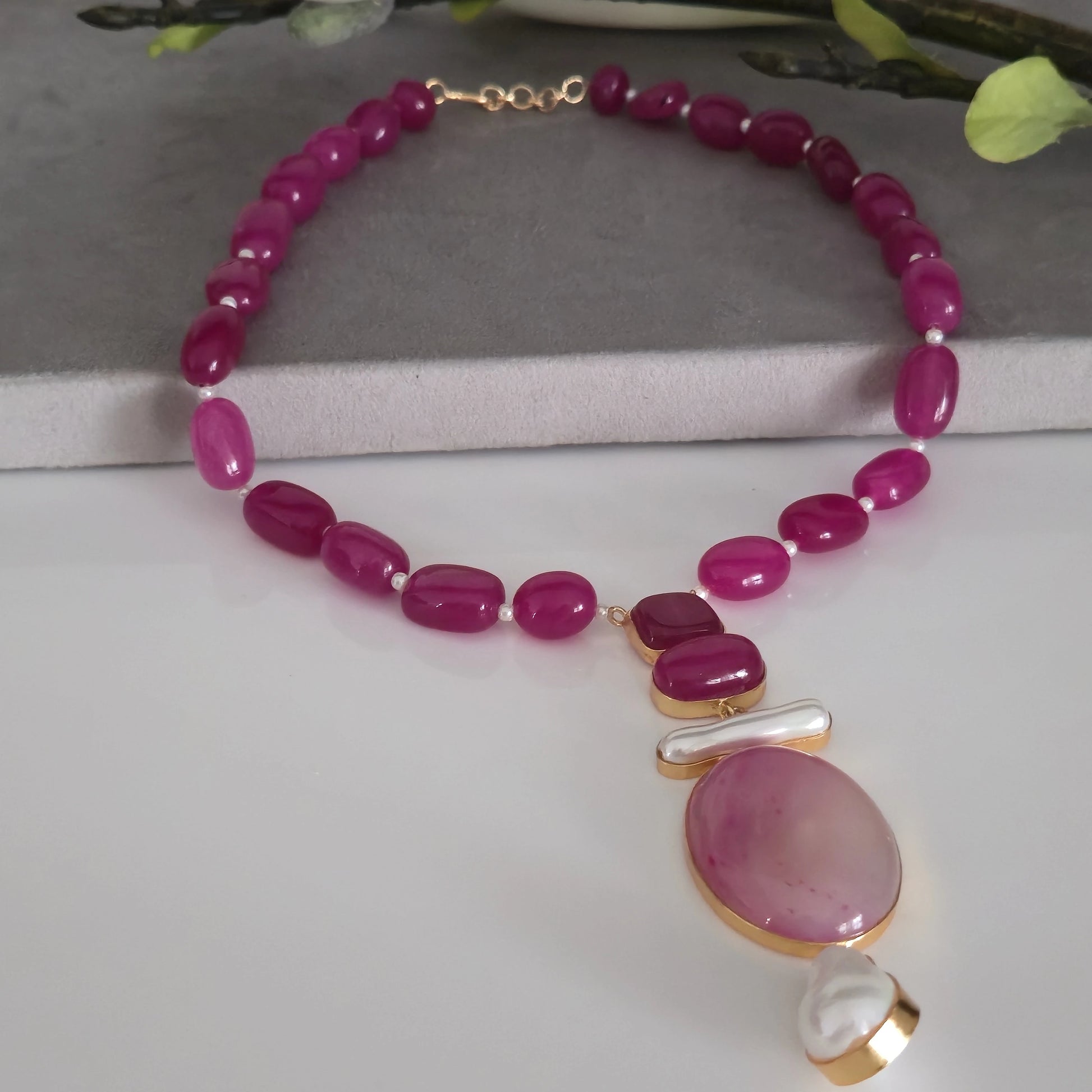 Vibrant fuchsia pink agate oval beaded necklace with large pink oval agate and pearl pendant, collier agate rose on a white background