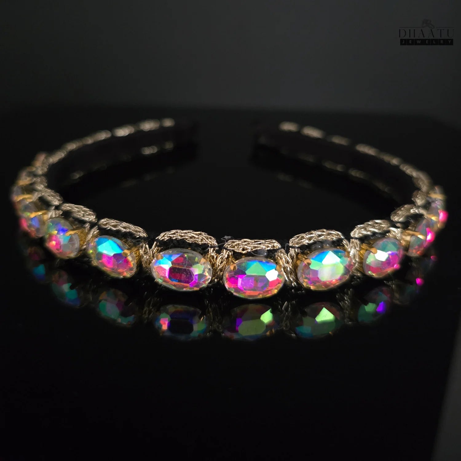 Eye-catching Western headband featuring iridescent crystals with a rainbow sheen and golden woven accents on a black background