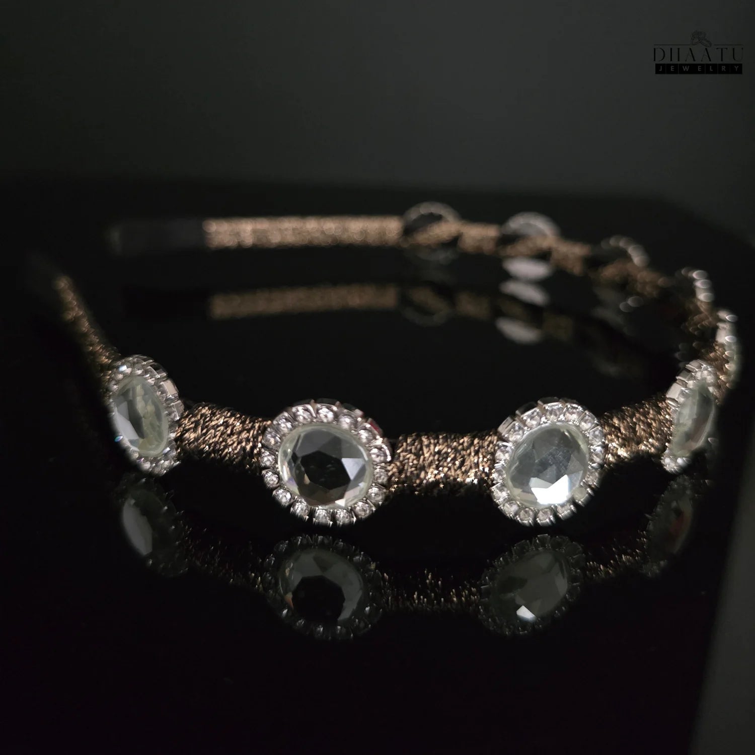 Modern crystal headband with a brown braided texture, shown from a side angle against a dark background, highlighting the embellishments