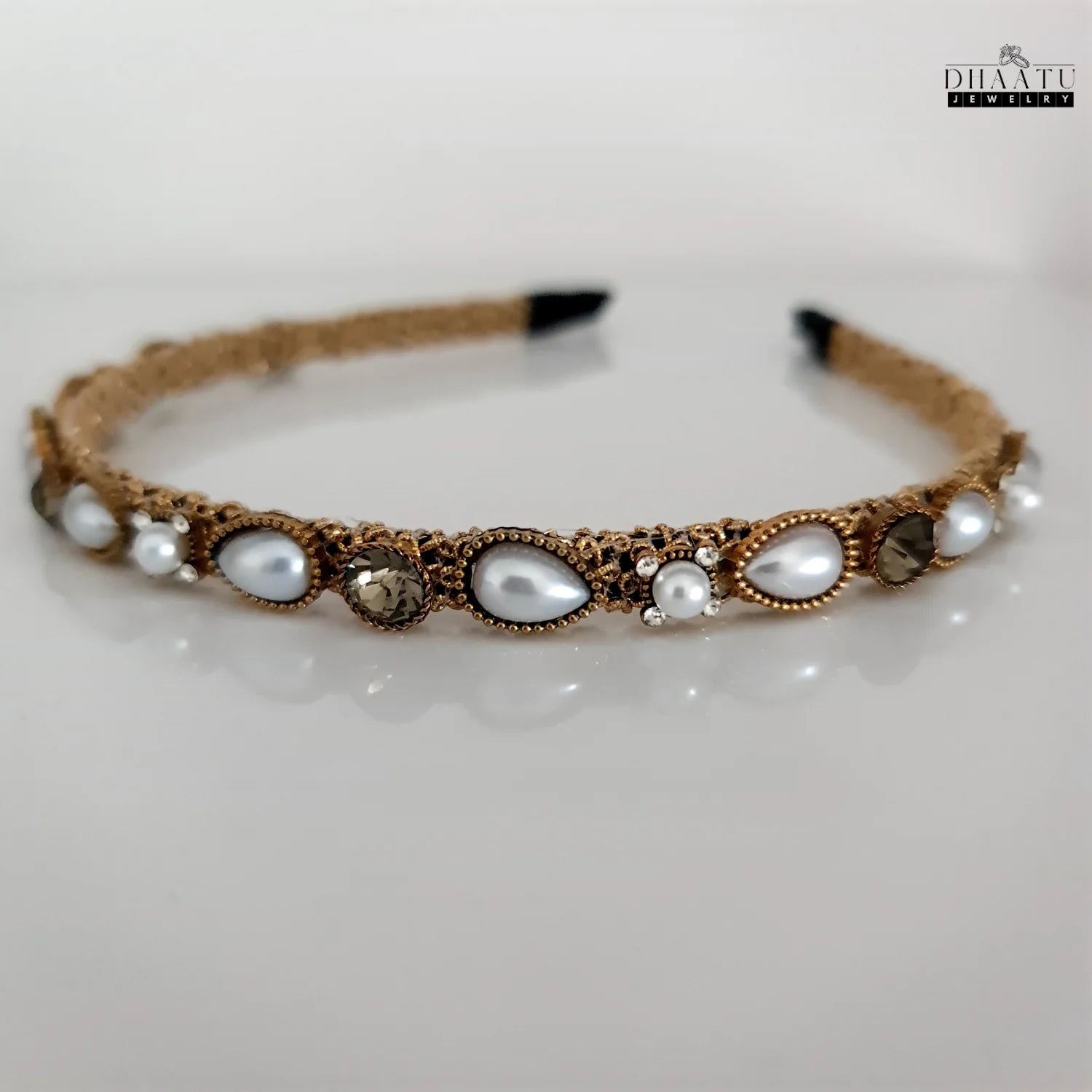 Gold-tone hairband with white pearls and sparkling crystals against a bright white background, showcasing Dhaatu Jewelry craftsmanship