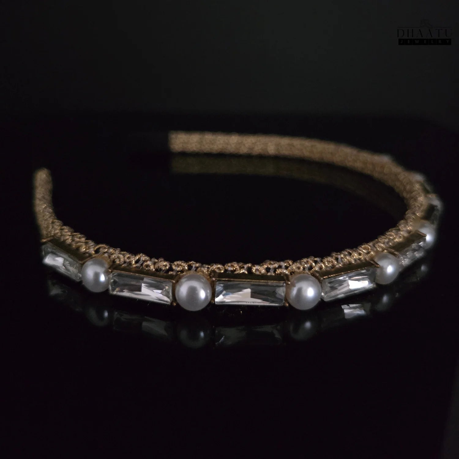 Side angle of a modern gold hairband featuring white pearls and clear crystals, perfect for special occasions