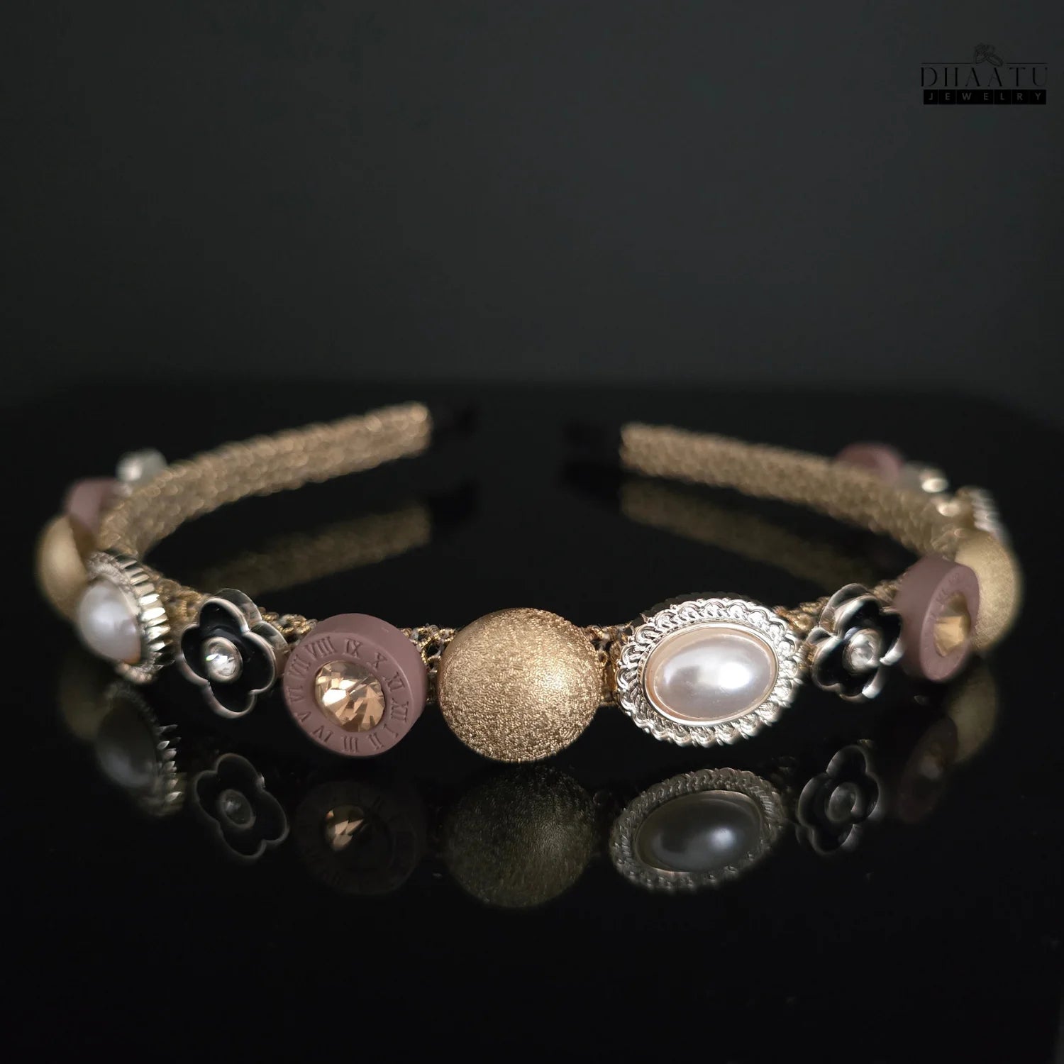 Close-up view of a modern Western hairband showcasing textured gold beads, faux pearl details, and unique mauve beads with Roman numerals and crystals