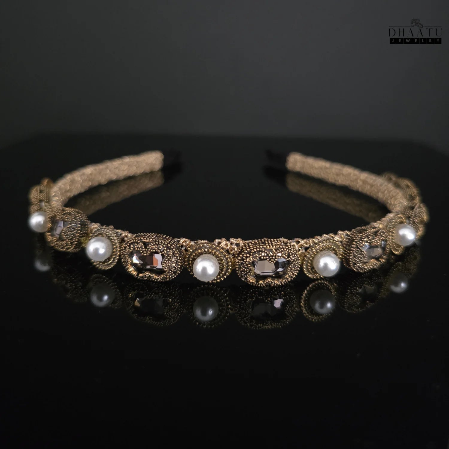 Modern western gold-toned headband featuring pearls and crystals against a dark background for dramatic effect