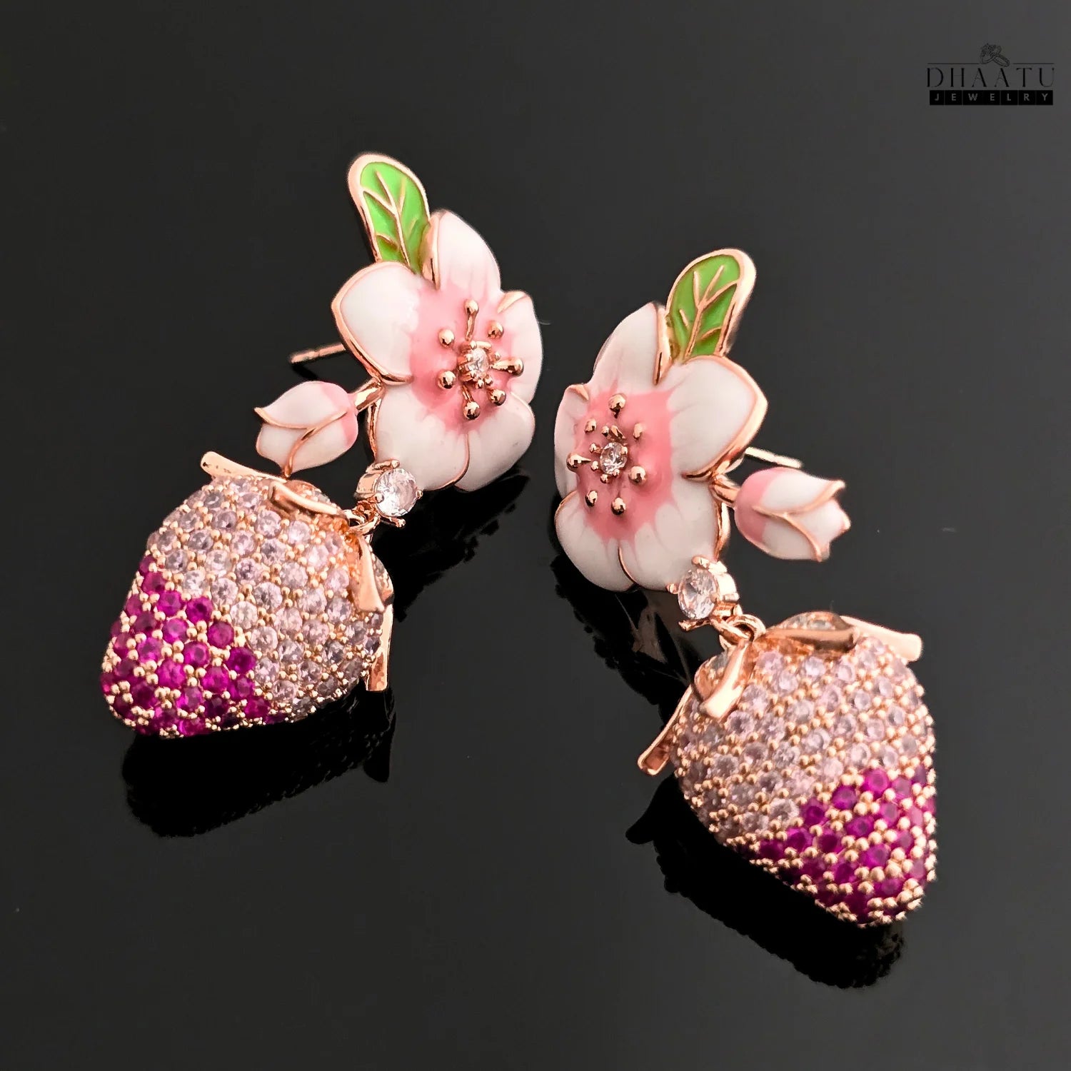 Floral and strawberry-themed earrings on a black background