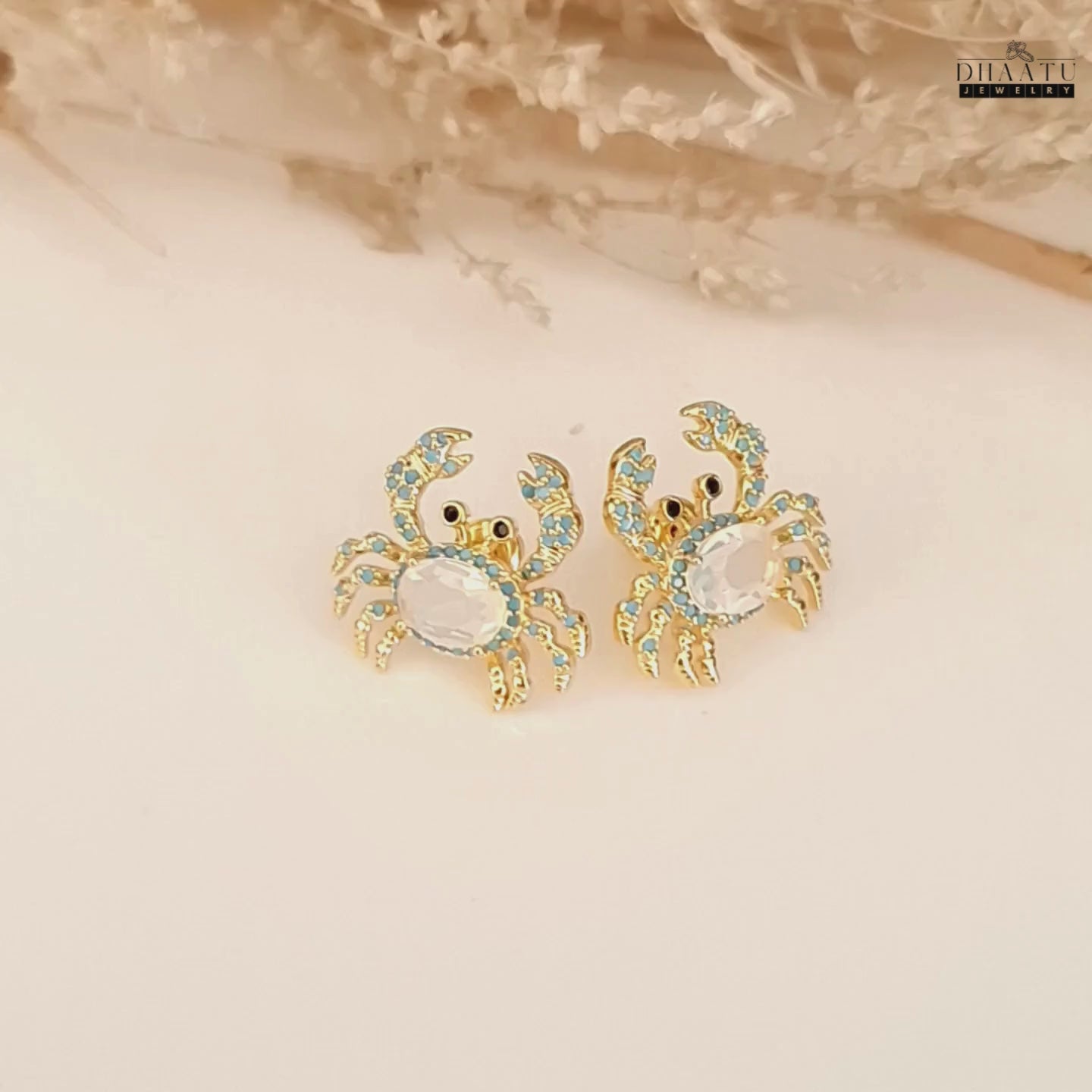 Load video: A video showcasing the gold-toned crab earrings from multiple angles, highlighting the turquoise and white zircon stones.
