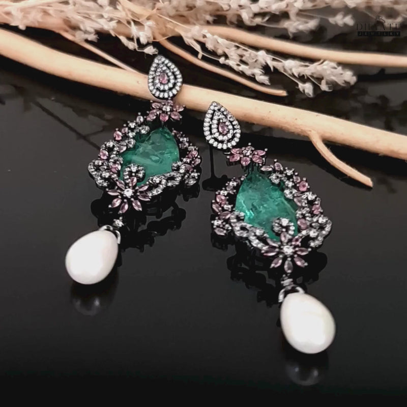 Video showcase of DHAATU JEWELRY green AD stone and pearl drop earrings, highlighting their details and movement.