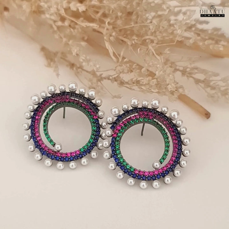 A short video showcasing the Dhaatu Jewelry multi-color spiral stud earrings from various angles, highlighting the sparkling gemstones and pearls.
