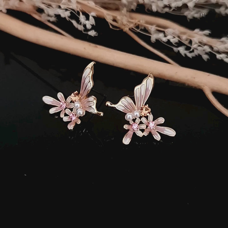 Video showcasing the pink and white butterfly and flower stud earrings with pearl and crystal details on black background.