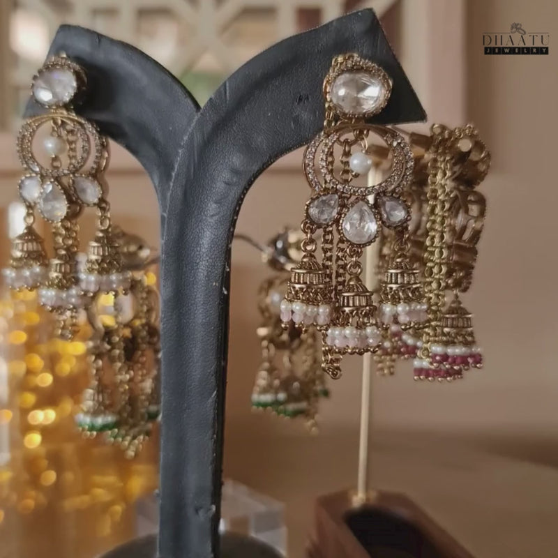 360 deg video showcasing the intricate details and varied bead color options (green, pink, maroon) of Kundan Jhumka earrings on display stands.