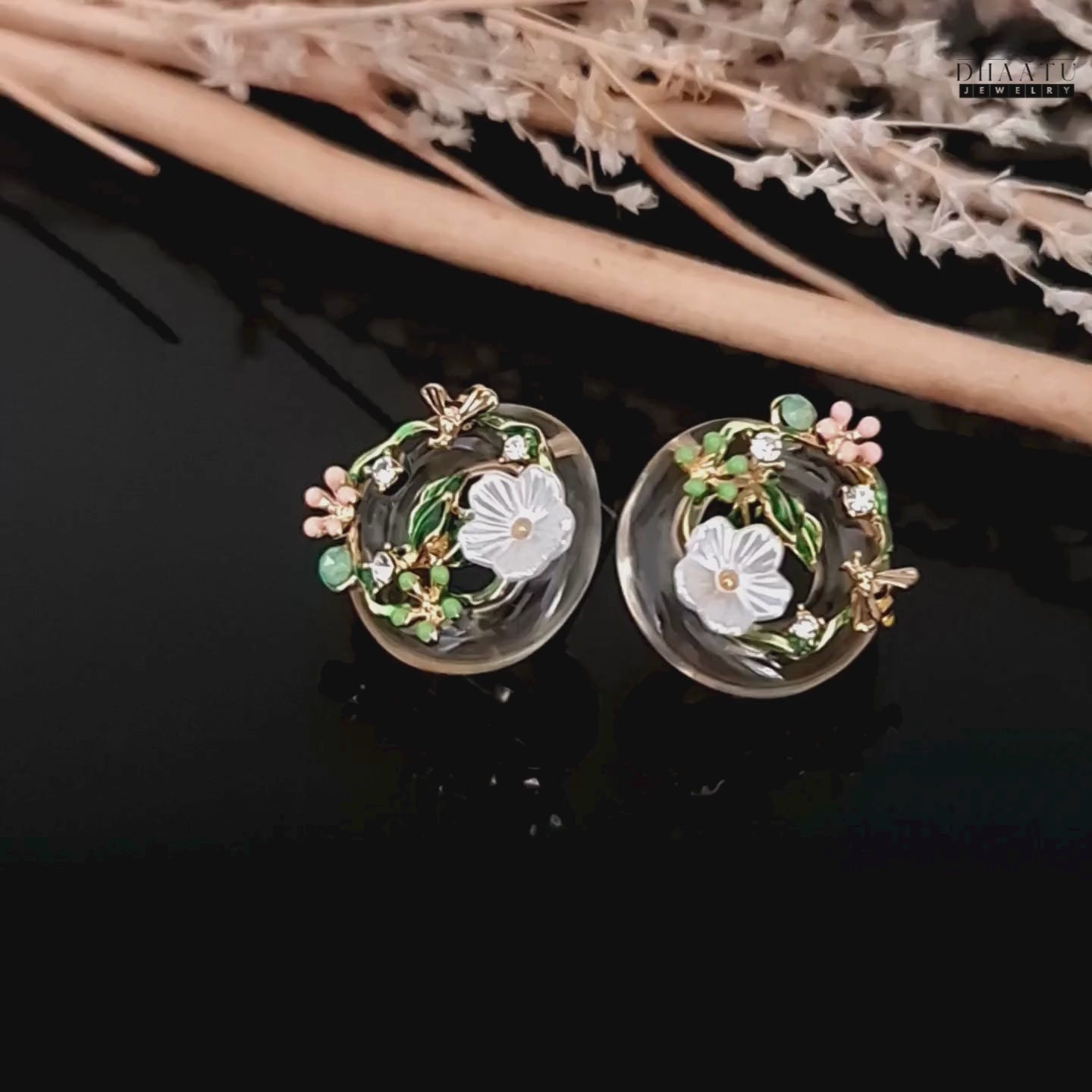 Load video: A video showing a 360-degree view of the DHAATU JEWELRY floral and bee stud earrings, capturing the light and intricate details of the design.