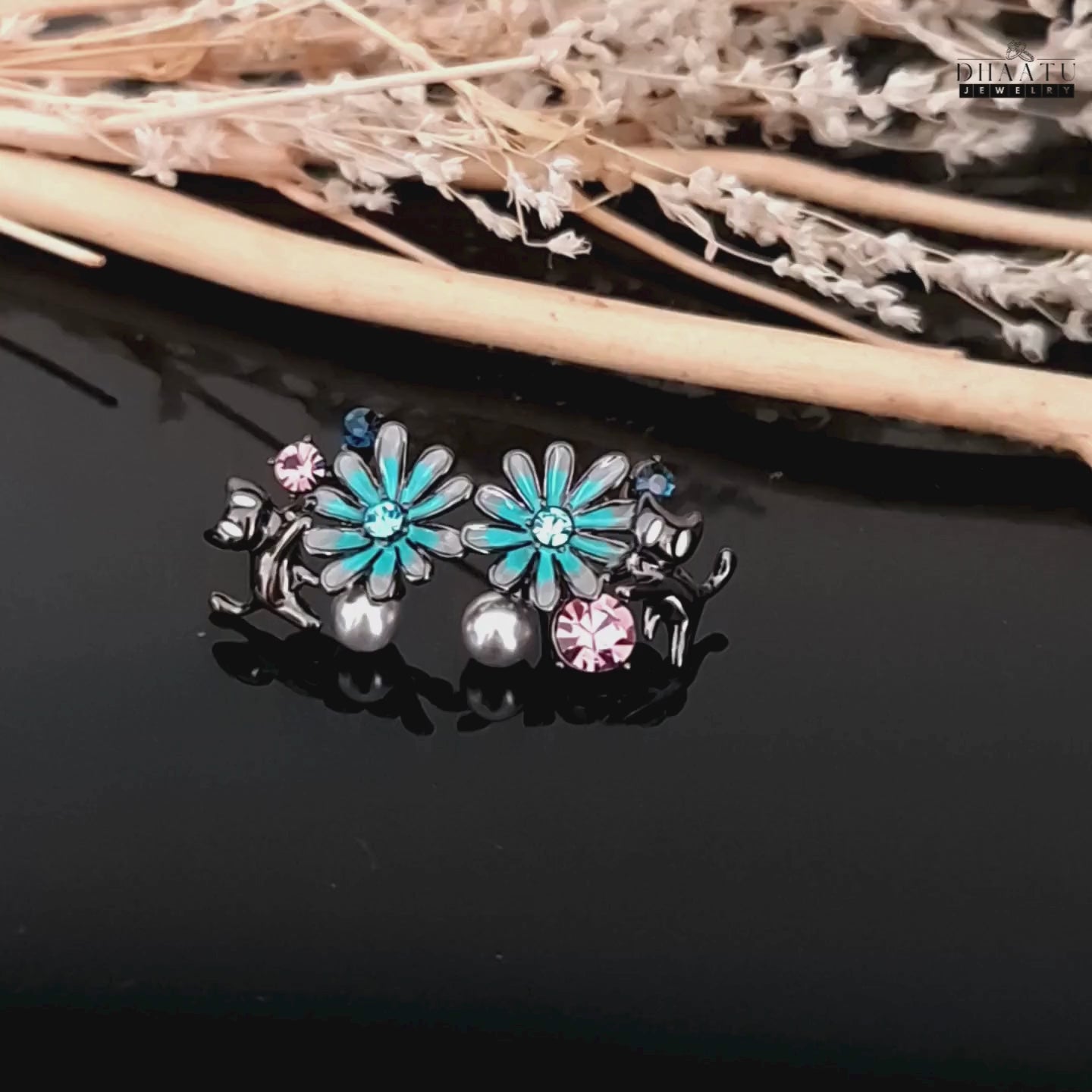 Load video: A short video clip of the gunmetal cat and floral earrings, showing their intricate design and luster.