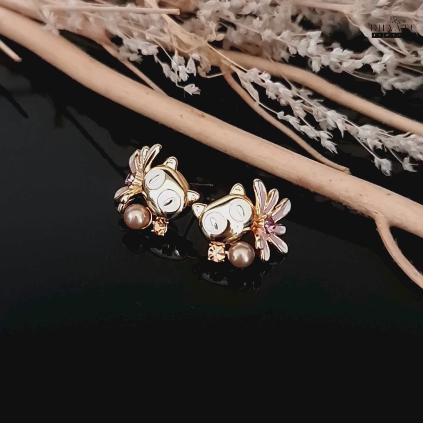 Load video: Video showcasing the Dhaatu Jewelry owl earrings with white eyes and mocha pearl, set against a natural decor.