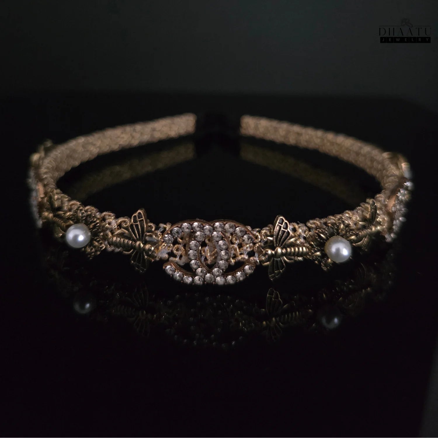 Front view of a regal gold and pearl embellished crystal hairband against a dark background, highlighting sparkling crystals and pearls