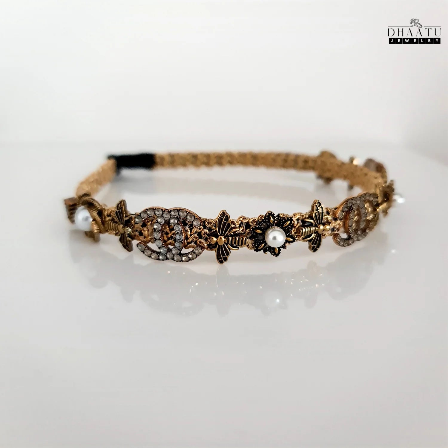Regal gold and pearl embellished crystal hairband on a clean white background, showcasing intricate details and modern western design