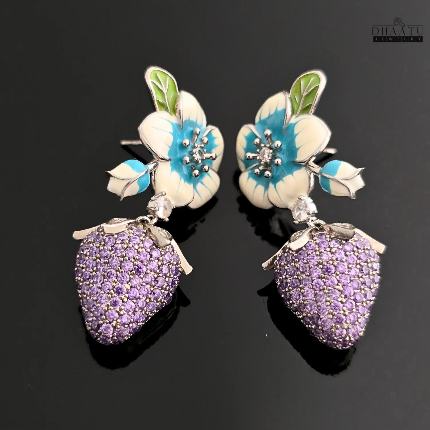 Pair of silver-plated drop earrings with white and blue enamel flowers and purple CZ strawberry charms, shown on a black background.